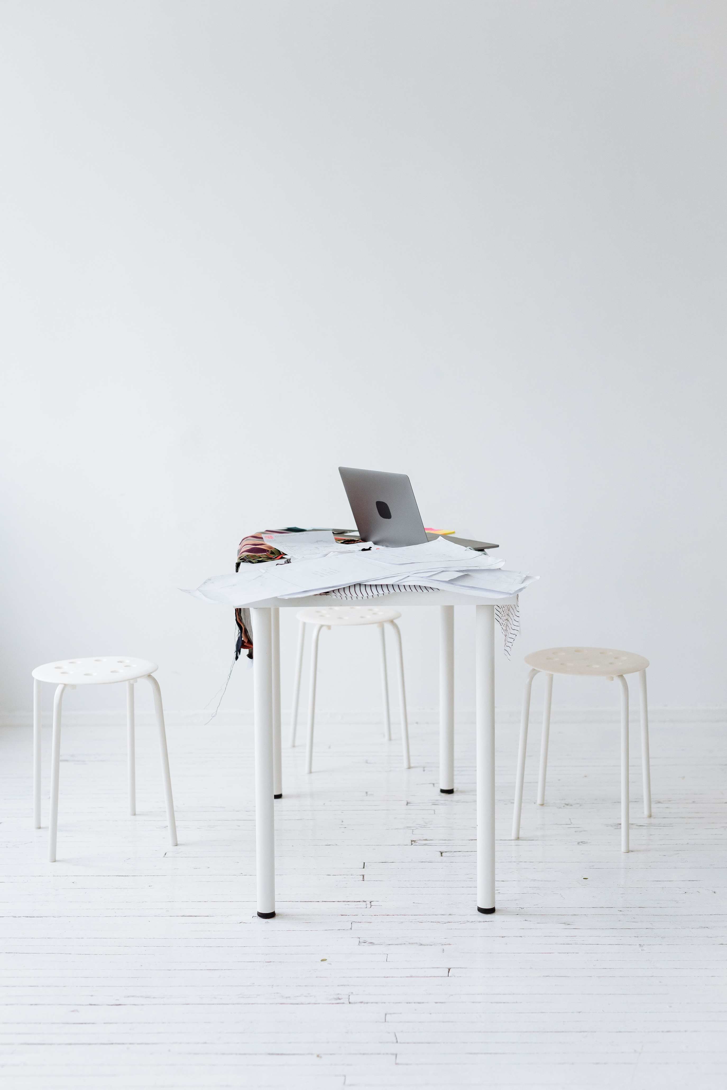 Aufgeräumter Schreibtisch mit Laptop und offenem Notizbuch
